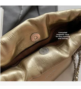 Detail of the hidden magnetic closure and gold metallic texture on the bucket bag