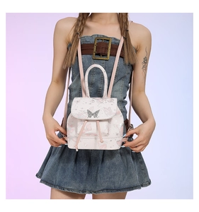 Detail of pink butterfly print backpack featuring metal buckle and drawstring closure