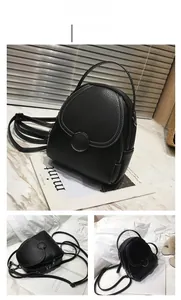 Detail of black mini backpack with lychee texture leather and round decorative buckle