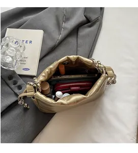 Interior view of gold cloud bag showing spacious storage for phone and cosmetics