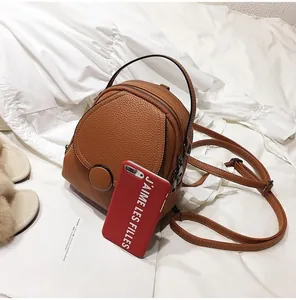 Detailed view of mini brown lychee pattern leather backpack showing texture and strap
