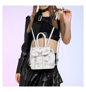 Detailed view of mini white PU leather backpack with silver butterfly prints and metal clasp