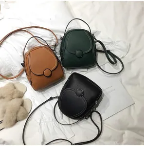 Detailed view of mini PU leather backpacks in brown, green and black with round buckles