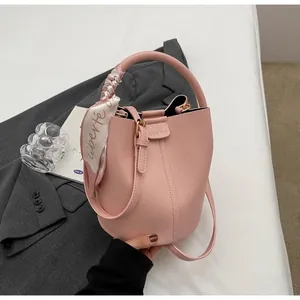 Sac seau rose à grain de litchi avec une poignée décorée d'un foulard en soie