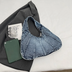 Chic washed blue denim crescent shoulder bag with vertical stitching on white background