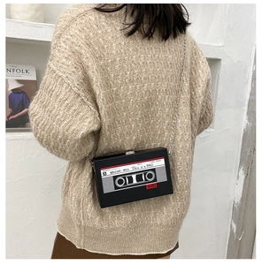 Rear view of a black retro cassette tape crossbody bag with a slim metal chain strap