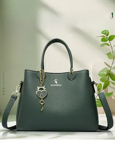 Detail of dark green lychee grain leather handbag with gold heart lock charm