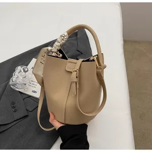 Sac seau en cuir grainé beige avec poignée en foulard de soie et logo Chic 21 gravé