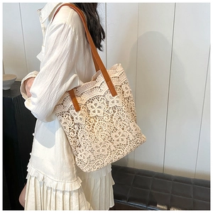 Detail view of floral lace tote bag with brown leather straps on a model