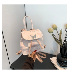 Detail of floral butterfly print on pink faux leather backpack with sequin clasp