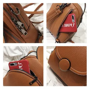 Detail view of brown lychee leather backpack with metal zippers and anti-theft back pocket