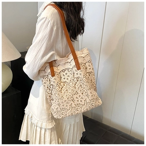 Lace crochet tote bag with brown leather shoulder straps shown on a model