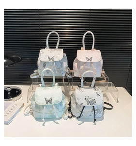 Detailed close-up of four pastel mini backpacks with metallic butterfly clasps and prints