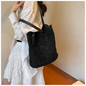 Close-up of intricate black lace texture and floral patterns on a women's tote bag