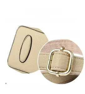 Detail of beige lychee leather bag base with golden adjustable metal buckle