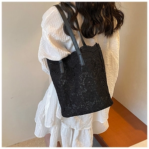 Detail of elegant black floral lace pattern on a large capacity summer tote bag