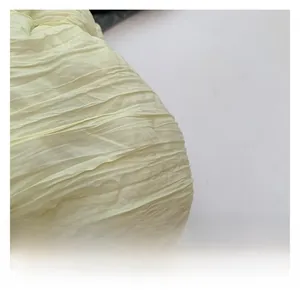 Vue détaillée de la texture plissée sur le tissu crème de ce sac à bandoulière