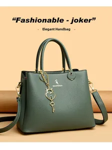 Close-up of dark green lychee pattern leather handbag with golden heart charm and logo