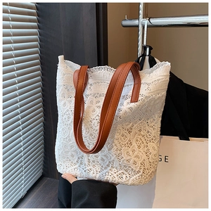Detailed macro view of white floral lace pattern on a stylish summer bucket tote bag