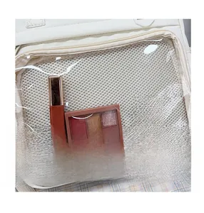 Close-up of a white leather backpack showing a clear PVC front pocket with gold zipper