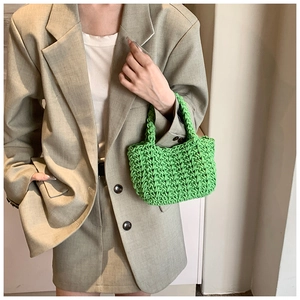 Dettaglio di mini borsa verde brillante tessuta a mano con spessa trama a maglia