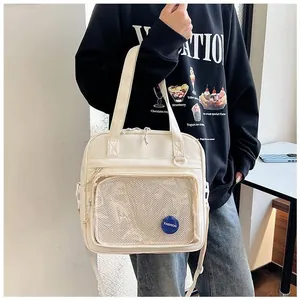 Detail of cream white ita bag with transparent mesh pocket and fashion label strap