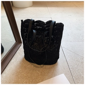 Detail of black lace tote bag featuring intricate floral patterns and PU shoulder straps
