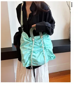 Detail view of mint green pleated canvas tote bag with dark green handles and drawstrings