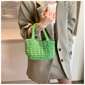 Dettaglio della borsa a mano in maglia verde con trama intrecciata a mano in rilievo