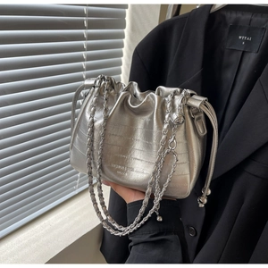 Detail view of silver pleated cloud bucket bag with chain strap and metallic finish