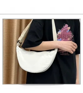 Détail d'un sac bandoulière blanc en nylon en forme de lune avec sangle réglable