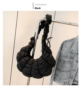 Détail d'un sac nuage noir matelassé montrant la texture bouffante et la bandoulière