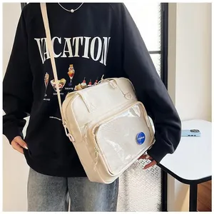Detail of cream white canvas crossbody bag with fashion label on mesh front pocket