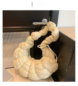 Détail du sac croissant beige montrant la texture plissée et le tissu doux