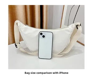 Sac bandoulière demi-lune blanc en nylon avec iPhone pour comparer la taille