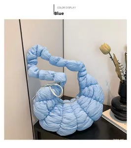Détail du sac croissant matelassé bleu clair avec texture plissée et tirette élégante