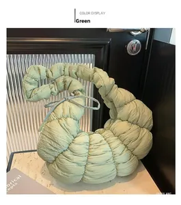 Vue détaillée du sac croissant vert clair matelassé avec texture plissée sur marbre