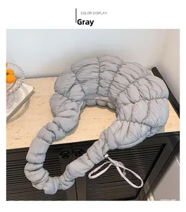 Détail du sac à main gris plissé à bulles posé sur une table en marbre d'intérieur