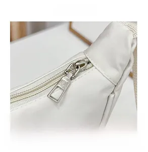 Vue détaillée de la fermeture éclair en métal argenté de qualité sur un sac beige