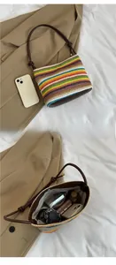 Detailed internal view of colorful striped straw bucket bag with brown faux leather strap