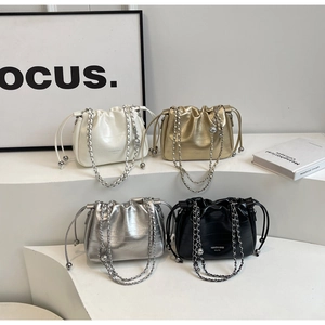 Four metallic drawstring bucket bags with chain straps in white, gold, silver, and black