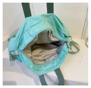 Spacious interior of light green canvas shoulder bag featuring a functional zip pocket