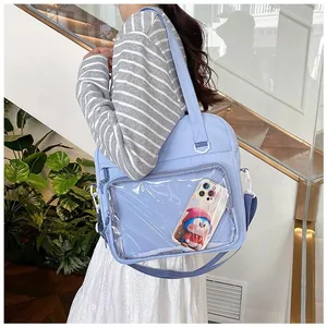 Detail of light blue ita bag with transparent window and adjustable dark blue strap
