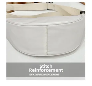 Vue détaillée du renforcement des coutures et bandoulière beige sur sac blanc