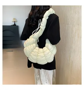 Vue détaillée du sac croissant plissé beige montrant le design texturé en nuage