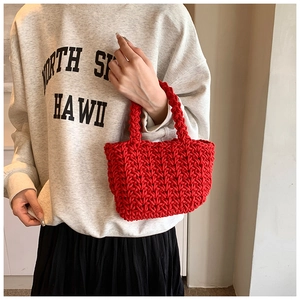 Dettaglio della borsa tote rossa intrecciata a mano con motivo a maglia strutturato