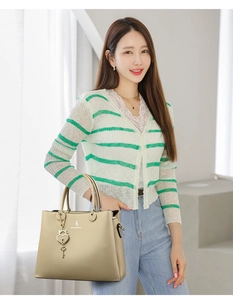 Detail of champagne gold leather tote bag with metallic deer logo and heart charm