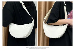 Détail de la bandoulière réglable et du sac croissant en nylon blanc porté en bandoulière