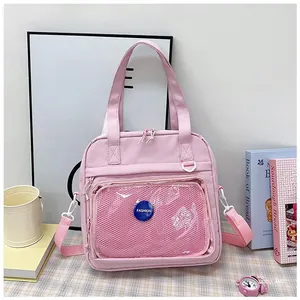 Pink canvas ita bag with transparent front pocket and fashion label on plaid background