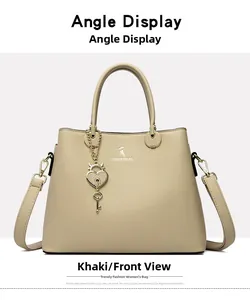Front detail of khaki trapezoid handbag with dual handles and heart key metal pendant